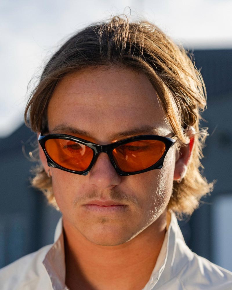 Smala svarta sportiga solglasögon med orange glas